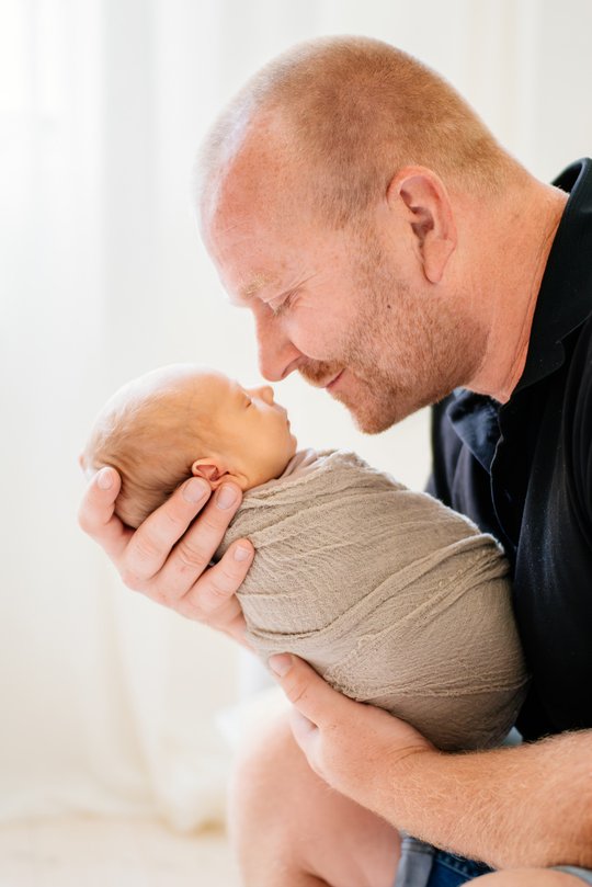 Vater und Neugeborenes Baby kuscheln