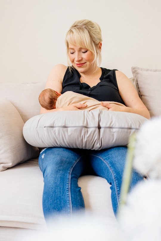 Mutter stillt Baby auf Sofa