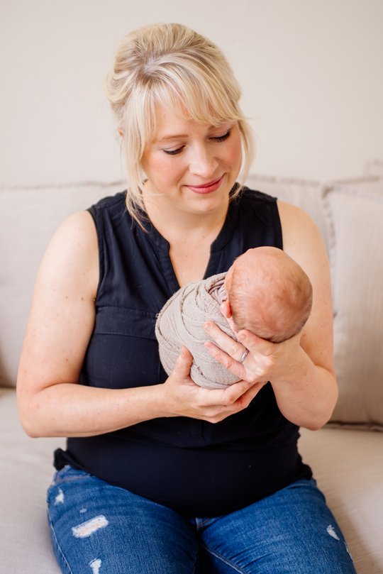 Mutter sitzt mit Baby auf dem Sofa